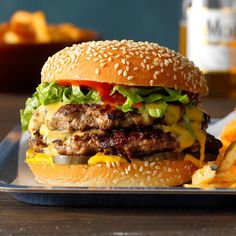 a cheeseburger with lettuce and tomato on a plate next to french fries