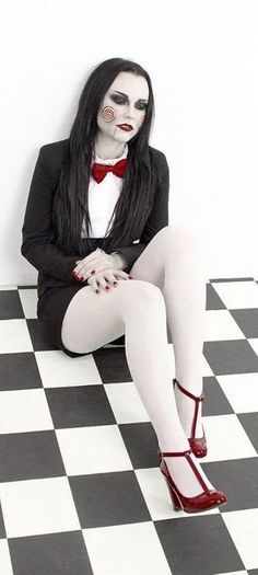 a woman sitting on top of a black and white checkered floor with her legs crossed