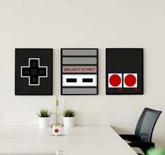 three framed video games are on the wall above a white table in an office setting