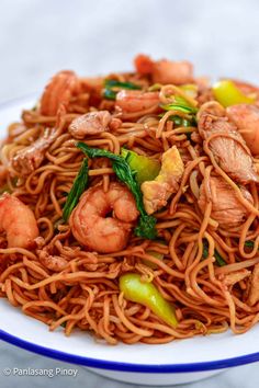 a white plate topped with noodles and shrimp