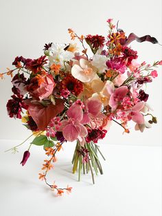 a vase filled with lots of different colored flowers