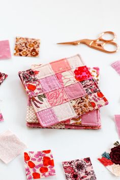 several pieces of fabric are laid out on a table with scissors and other crafting supplies