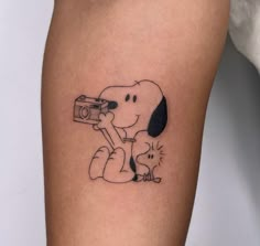 a small tattoo of a dog holding a camera