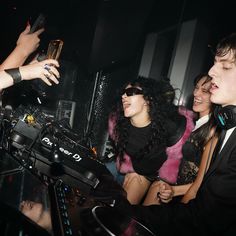 a group of people in a room with dj equipment