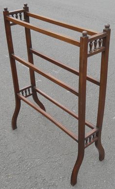 an old wooden rack is sitting on the pavement in front of a parking lot with no one around it