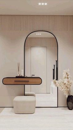 a bathroom with a mirror, stool and vase on the floor in front of it