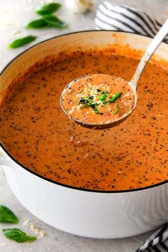 a spoon full of soup is being held up