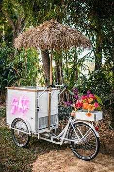 a bike with a cart attached to the back and flowers in the basket on the front