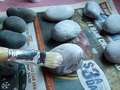 there are some rocks and a paintbrush on the table