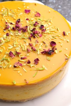 there is a yellow cake with flowers on the top and bottom, sitting on a white plate