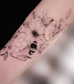 a woman's arm with flowers and a honeycomb tattoo on the left forearm