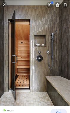 a walk in sauna with tiled walls and flooring next to a shower stall