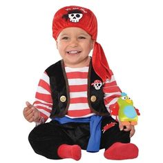 a little boy wearing a pirate costume sitting on the ground with a stuffed animal in his hand