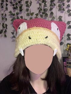 a woman wearing a crocheted hat with two birds on it's head