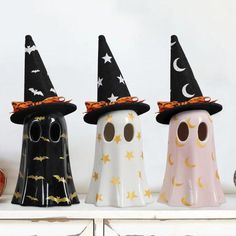 three halloween candles are sitting on a shelf