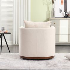 a living room scene with focus on the round chair and white rug in the foreground