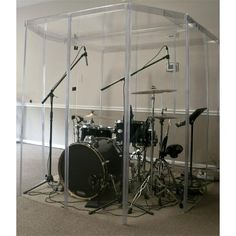 a drum set in a clear room with microphones