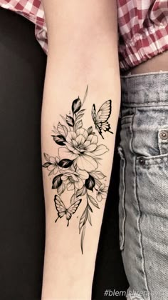 a black and white flower tattoo on the arm