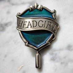 a badge with the word headgirl on it sitting on top of a marble surface