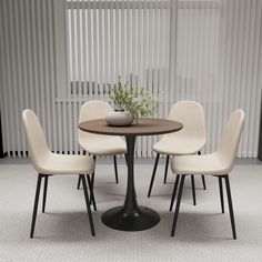 a round table with four chairs around it and a vase on the top, in front of vertical blinds