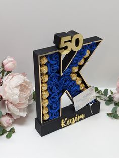 the letter k is decorated with gold and blue flowers