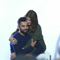 a man and woman hugging each other while sitting on a white chair with their arms around each other