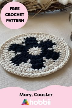 a crocheted black and white plate sitting on top of a table next to a basket