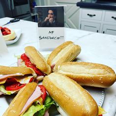 several sandwiches are arranged on a plate with a card in the middle that says mr sandwhich