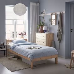 a bedroom with a bed, dresser and window