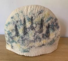 This is a wet felted tea cosy hand made using Corriedale wool in my workshop in sunny Suffolk. It is made in one piece to create a seamless design. As each piece is hand made, every one is unique and the design on each side is different (the photos show both sides). Wool is a natural insulator so this will keep your tea nice and hot. It measures 32cm wide by 23cm tall and will easily accommodate a standard 3/4 person teapot. It fits over the complete teapot including handle and spout. The tea co Table Art, Tea Cosy, Tea Cozy, Art Table, Tea Lover, Wool Felt, Tea Pots, Unique Gifts, Felt