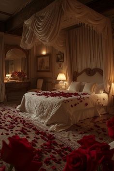 a bed with rose petals on the floor in a room that looks like it has been decorated for valentine's day