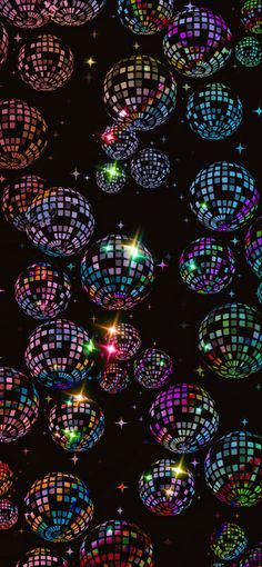 many disco balls are lit up in the dark with colorful lights and stars around them