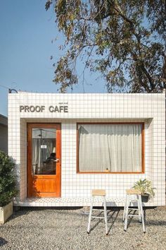 a small white building with two chairs in front of it