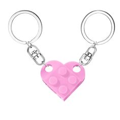 a pink heart shaped keychain with two holes in the shape of a lego