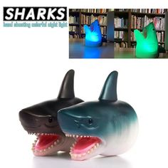 two shark shaped lights sitting next to each other in front of a book shelf with bookshelves