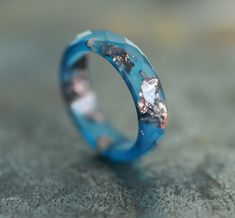 * ONE blue resin ring from my resin jewelry collection * resin band ring - 4-5 mm/0.16 - 0.19 inches/width  * thickness - about 2.3 - 2.5 mm/about 0.09 inches/ * faceted ring with unique flakes pattern * natural color ring - ocean blue ring with copper flakes/rose gold leaf * resin ring men and women, unisex   You can see the other resin rings from the collection here: https://www.etsy.com/shop/ARTISUNtis?ref=seller-platform-mcnav&section_id=15714637 Features: * Hypoallergenic ring (suitable for the people with metal allergy) * For everyday and for special occasions * Perfect gift for you or for the special one in your life  * Stacking ring - you can wear it on its own or stacked with some other rings * Simple and elegant design * Comfort fit ring for wearing * Lightweight ring - pleasant Unique Blue Resin Rings, Handmade Blue Resin Rings, Blue Resin Rings For Gifts, Blue Resin Rings Perfect As Gifts, Blue Resin Rings Perfect For Gifts, Resin Rings, Faceted Ring, Unique Birthday Gift, Blue Ring