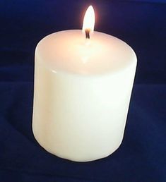 a white candle is lit on a black background