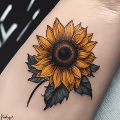 a sunflower tattoo on the thigh with leaves