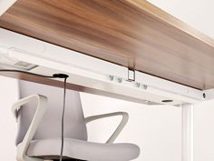 an office chair is connected to the underside of a desk with a wooden shelf above it