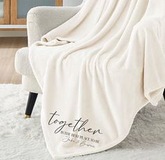 a white chair with a personalized throw blanket on it's back in a living room