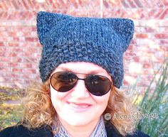 a woman wearing sunglasses and a knitted cat hat