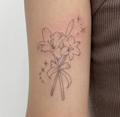 a woman with a tattoo on her arm has a bouquet of flowers in the shape of a bow