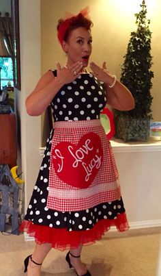 a woman in a polka dot dress is making a funny face with her hands and mouth