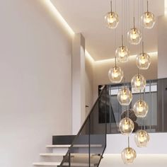 a modern staircase with glass balls hanging from it's handrail and stairs leading up to the second floor