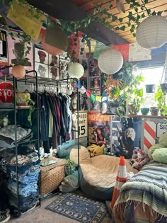 a room filled with lots of clutter and hanging plants on the wall next to a bed