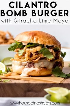 a close up of a sandwich on a cutting board with limes and cilantro