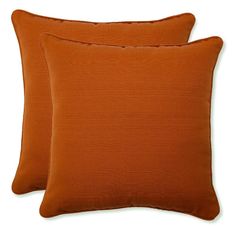 two orange pillows sitting next to each other