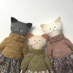 three knitted cats are sitting next to each other