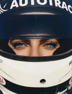 a woman wearing a racing helmet with her eyes wide open