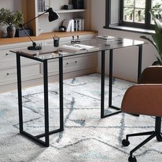 an office with a desk and chair in the corner, next to a potted plant